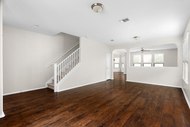 unfurnished living room with ceiling fan and dark wood-type flooring