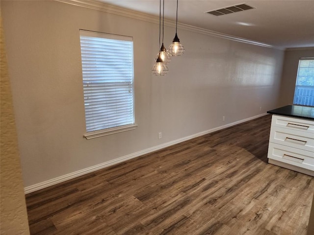 unfurnished dining area with dark hardwood / wood-style flooring and crown molding