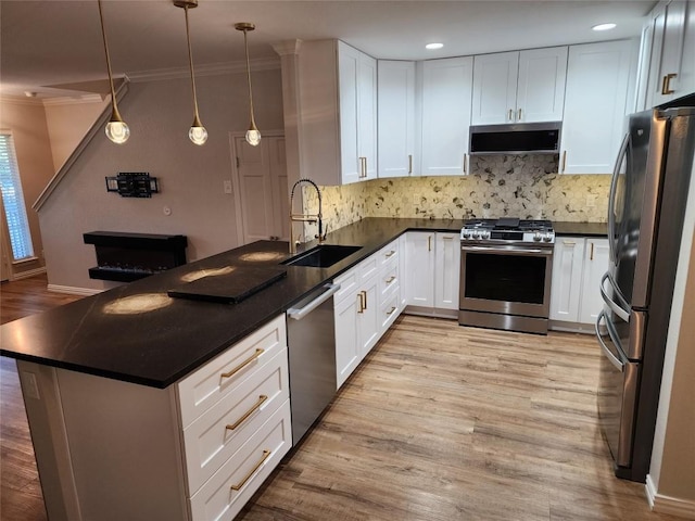 kitchen featuring white cabinets, decorative light fixtures, sink, and appliances with stainless steel finishes