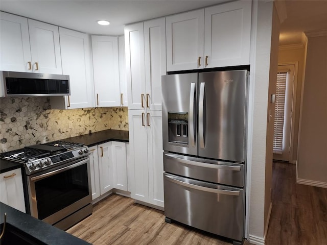 kitchen with decorative backsplash, stainless steel appliances, crown molding, light hardwood / wood-style flooring, and white cabinets