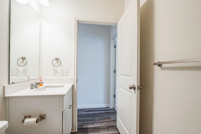 bathroom featuring vanity, wood-type flooring, and toilet