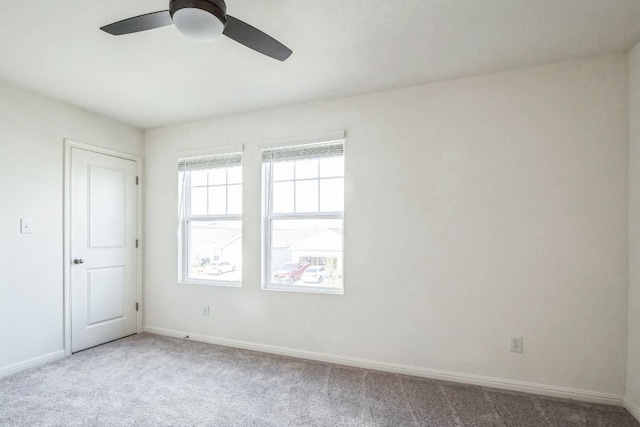 carpeted spare room featuring ceiling fan