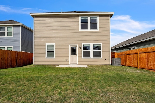 back of property with a yard and central AC