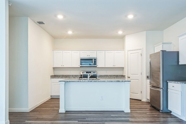 kitchen with a kitchen island with sink, sink, dark hardwood / wood-style flooring, white cabinetry, and stainless steel appliances