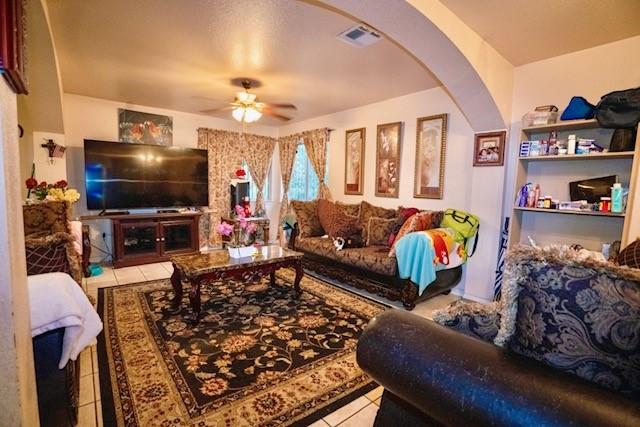 living room with ceiling fan and light tile patterned flooring