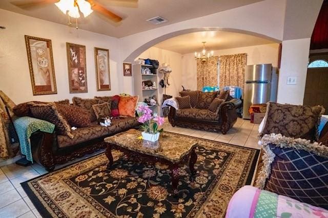 living room with ceiling fan with notable chandelier and light tile patterned floors