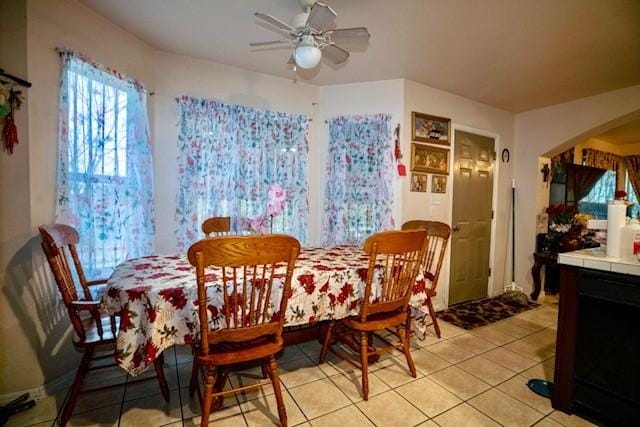 tiled dining area with ceiling fan