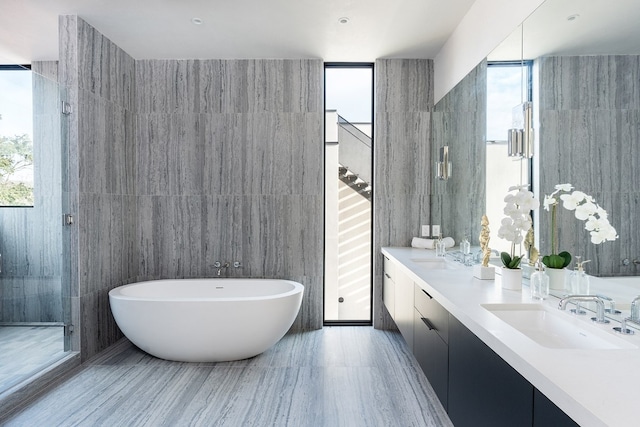 bathroom featuring vanity, a healthy amount of sunlight, and tile walls