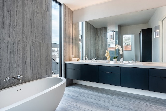 bathroom featuring vanity, a tub, and floor to ceiling windows