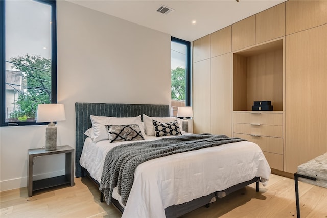 bedroom featuring multiple windows and light hardwood / wood-style floors