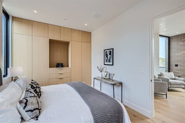 bedroom featuring expansive windows and light wood-type flooring