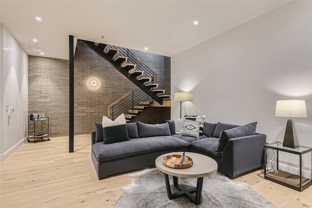 living room featuring light hardwood / wood-style flooring and brick wall