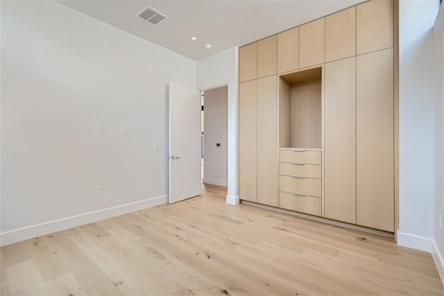 unfurnished bedroom with a closet and light wood-type flooring