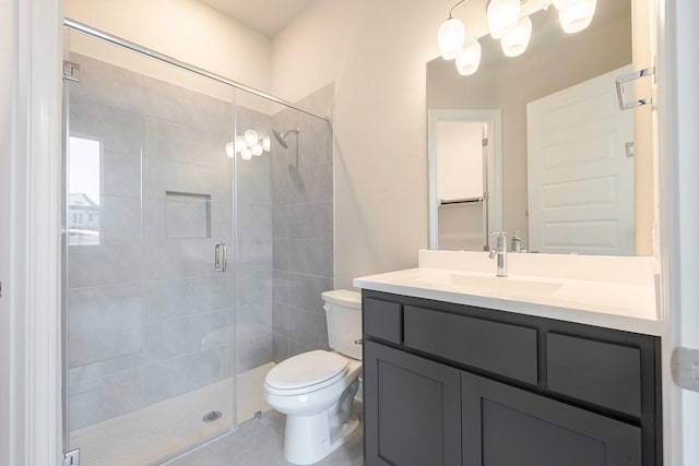 bathroom featuring tile patterned floors, vanity, an enclosed shower, and toilet