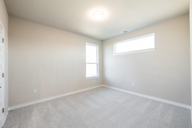 unfurnished room featuring light carpet