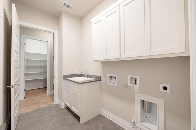 washroom featuring electric dryer hookup, gas dryer hookup, cabinets, sink, and washer hookup