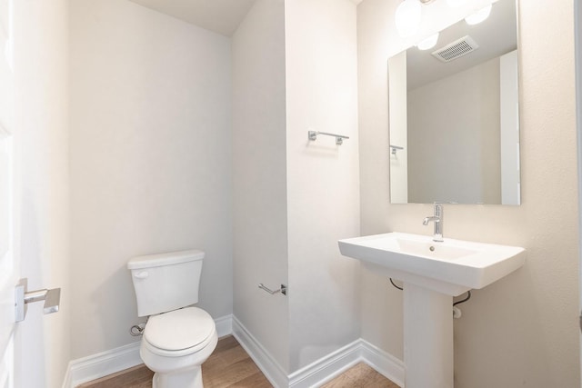 bathroom featuring wood-type flooring and toilet