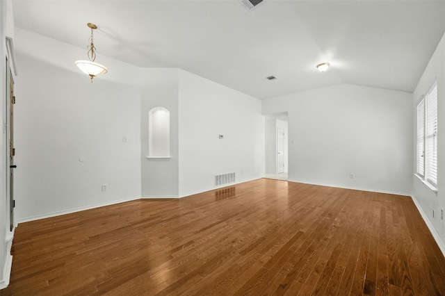 spare room with hardwood / wood-style floors and vaulted ceiling