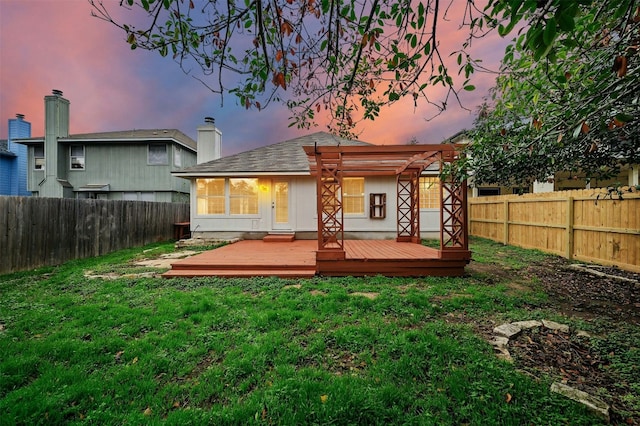 back house at dusk with a pergola, a yard, and a wooden deck