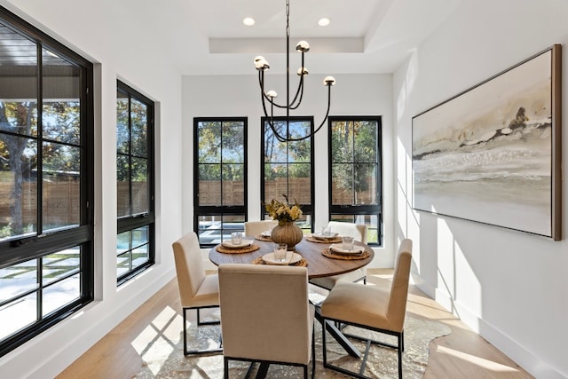 dining area with a healthy amount of sunlight, light hardwood / wood-style floors, and a chandelier