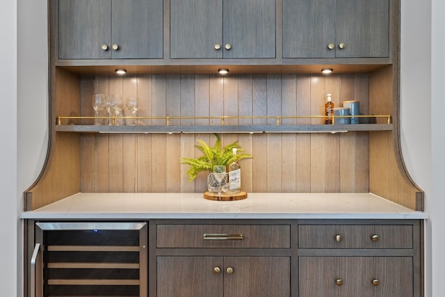 bar with dark brown cabinets and beverage cooler