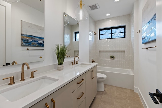 full bathroom with tile patterned floors, vanity, toilet, and tiled shower / bath combo