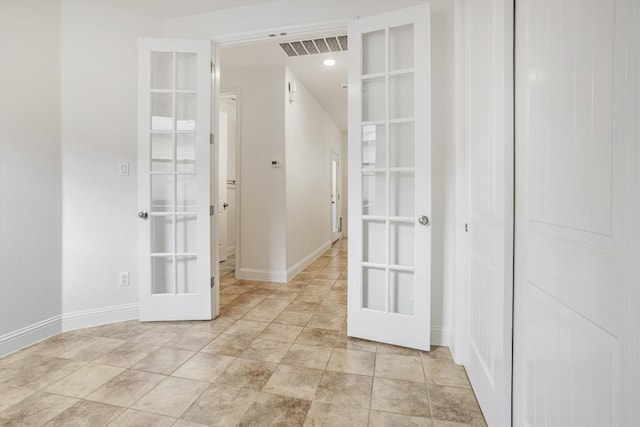 unfurnished room featuring french doors, visible vents, and baseboards