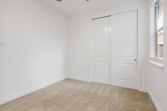 unfurnished bedroom featuring a closet, carpet flooring, and baseboards