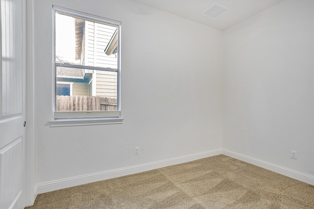 carpeted spare room featuring visible vents and baseboards