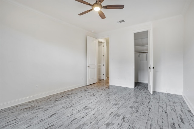 unfurnished bedroom featuring crown molding, ceiling fan, a closet, and light hardwood / wood-style flooring