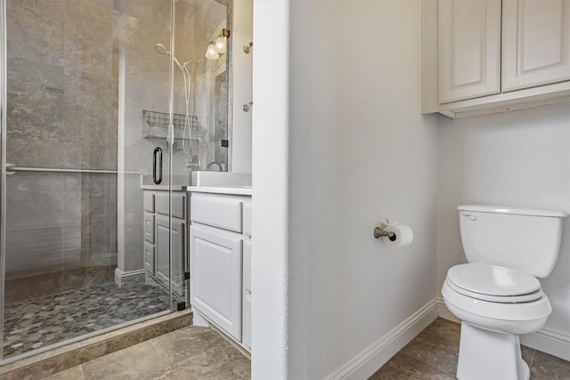 full bath with a stall shower, baseboards, vanity, and toilet