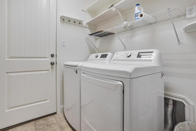 washroom with light tile patterned flooring and washer and clothes dryer