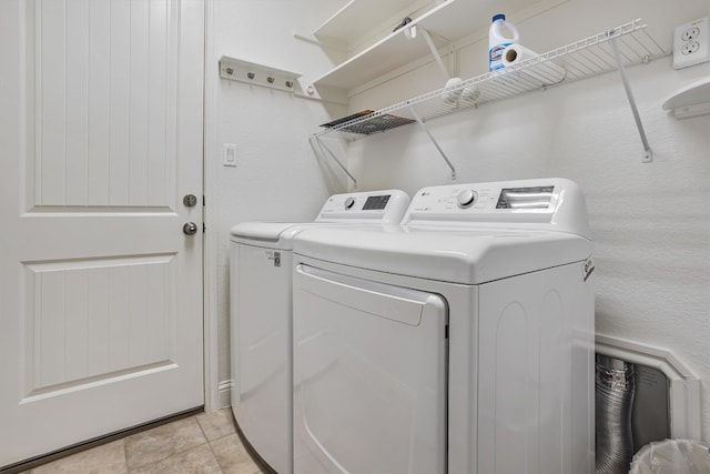 laundry room featuring laundry area, washer and clothes dryer, and light tile patterned flooring