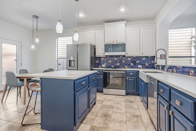 kitchen with pendant lighting, stainless steel appliances, white cabinets, and blue cabinets