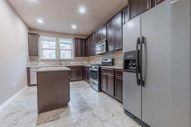 kitchen featuring appliances with stainless steel finishes, backsplash, a kitchen island, and dark brown cabinets