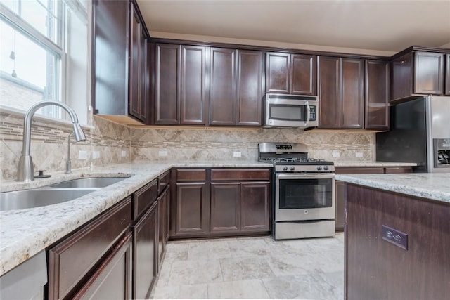 kitchen with decorative backsplash, dark brown cabinets, stainless steel appliances, and sink