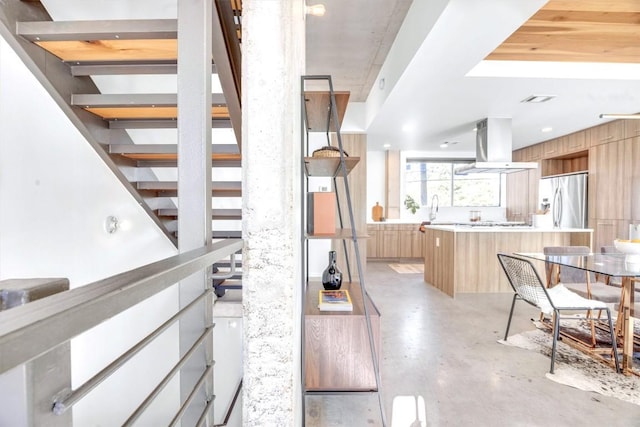 staircase featuring sink and concrete floors