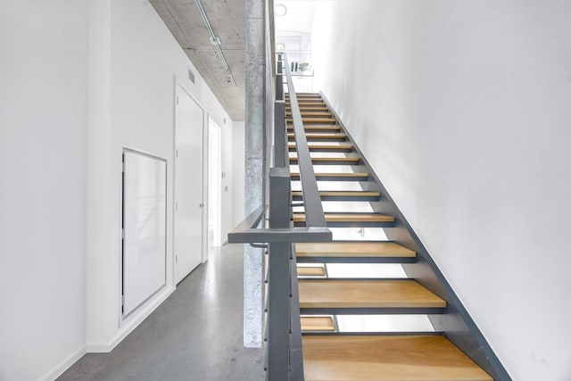 staircase with concrete flooring