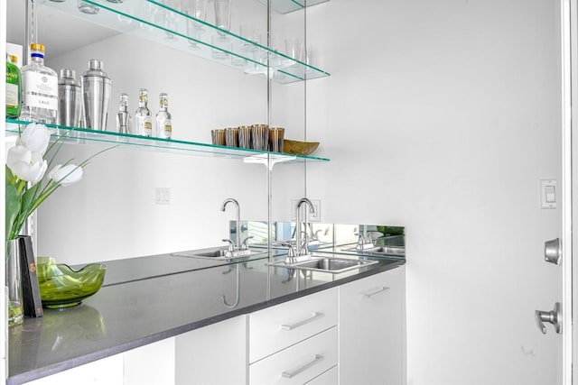 bar featuring sink and white cabinets