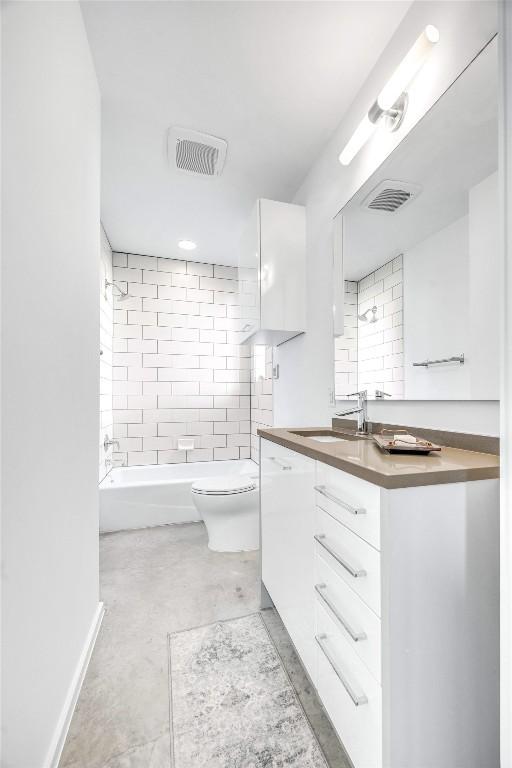 full bathroom with vanity, tiled shower / bath, and toilet