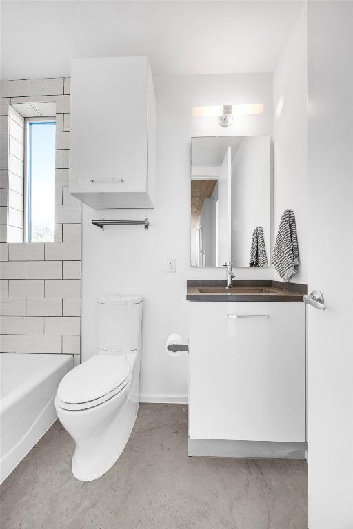 bathroom with vanity, concrete floors, and toilet