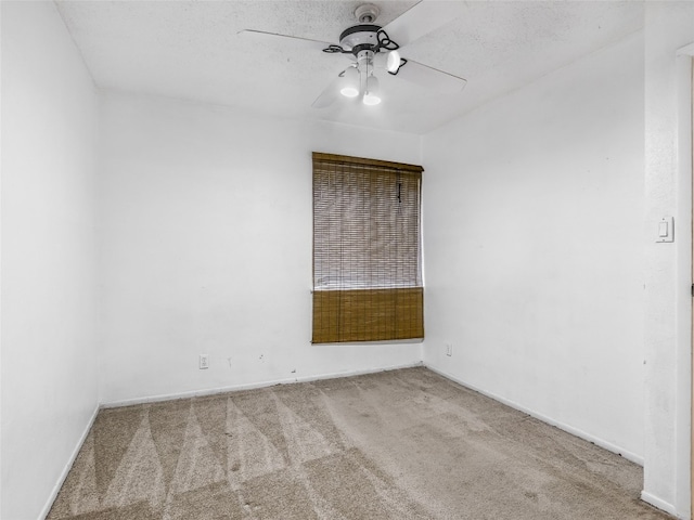 carpeted empty room with ceiling fan and a textured ceiling