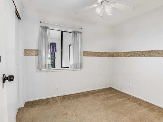 carpeted spare room with ceiling fan