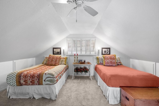 bedroom with ceiling fan, light colored carpet, lofted ceiling, and a textured ceiling