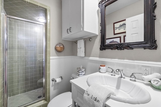 bathroom with vanity, a shower with shower door, and toilet