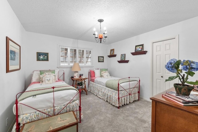 carpeted bedroom with a closet, a textured ceiling, and a chandelier