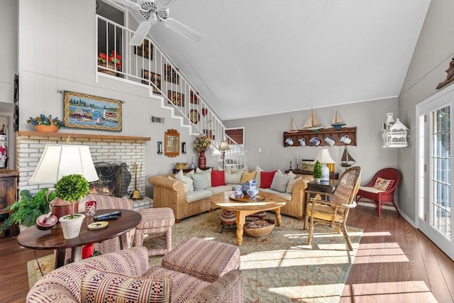 living room with a fireplace, hardwood / wood-style flooring, vaulted ceiling, and ceiling fan