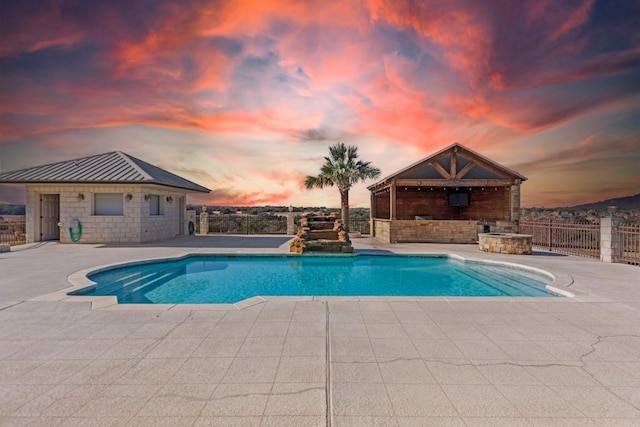 pool at dusk featuring a patio