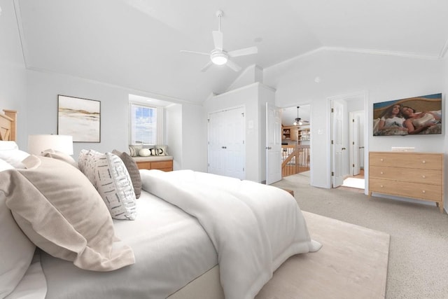 bedroom with ceiling fan, light colored carpet, lofted ceiling, and a closet