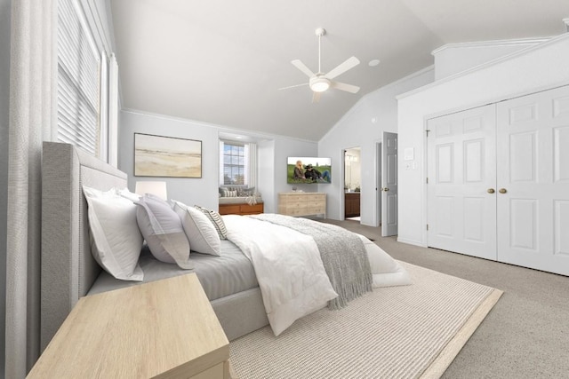 carpeted bedroom with ceiling fan, lofted ceiling, ornamental molding, and a closet